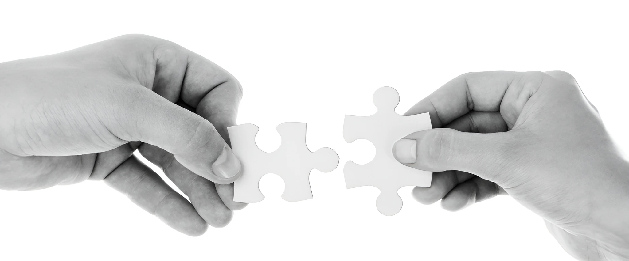 Two hands connecting puzzle-pieces together