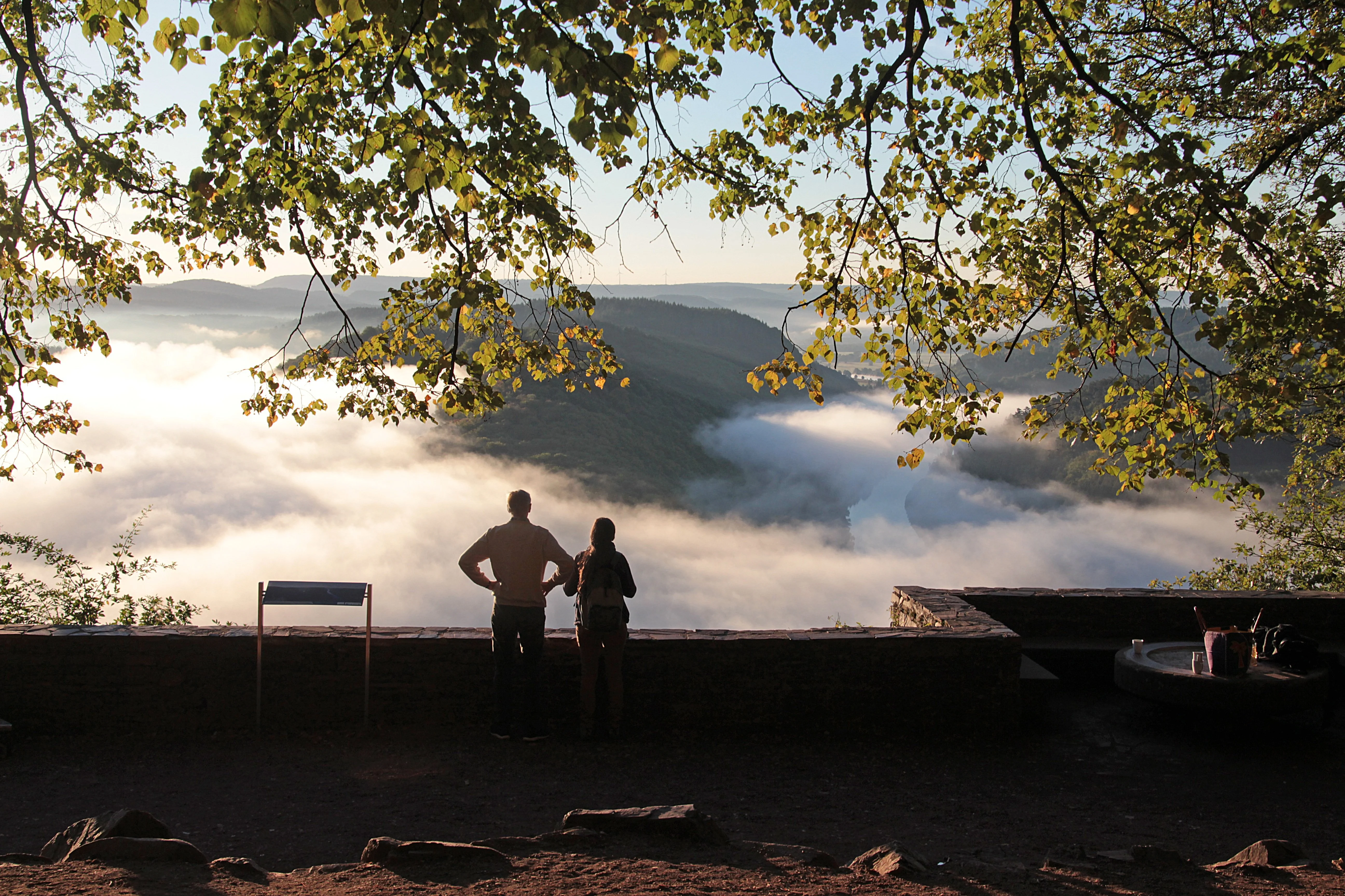Two people standing overlooking a mountain view.